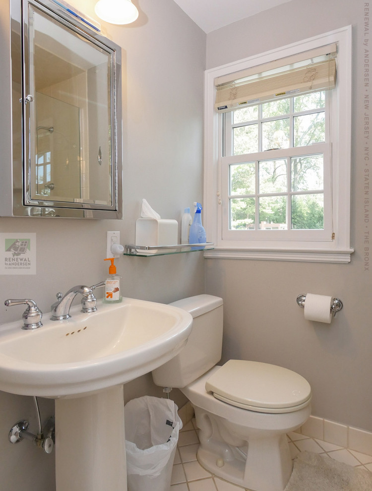 Inspiration for a small 3/4 bathroom in Newark with white cabinets, an alcove tub, a two-piece toilet, white tile, ceramic tile, grey walls, ceramic floors, a pedestal sink, white floor, a sliding shower screen, a single vanity and vaulted.