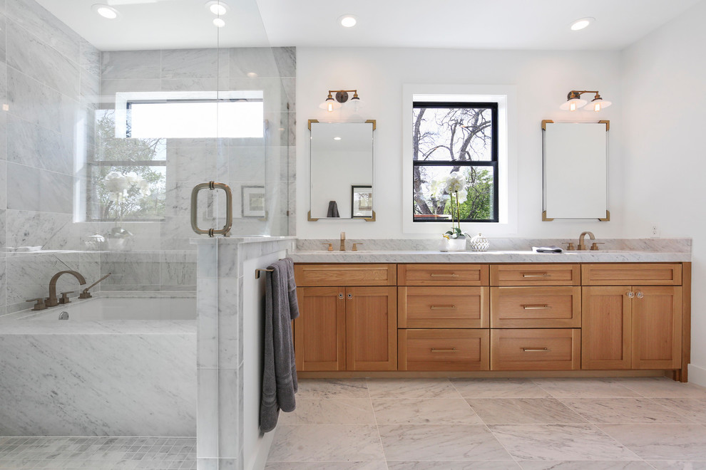 Photo of a scandinavian master bathroom in Dallas with shaker cabinets, light wood cabinets, a shower/bathtub combo, white tile, marble, white walls, marble floors, an undermount sink, engineered quartz benchtops, multi-coloured floor, a hinged shower door and white benchtops.