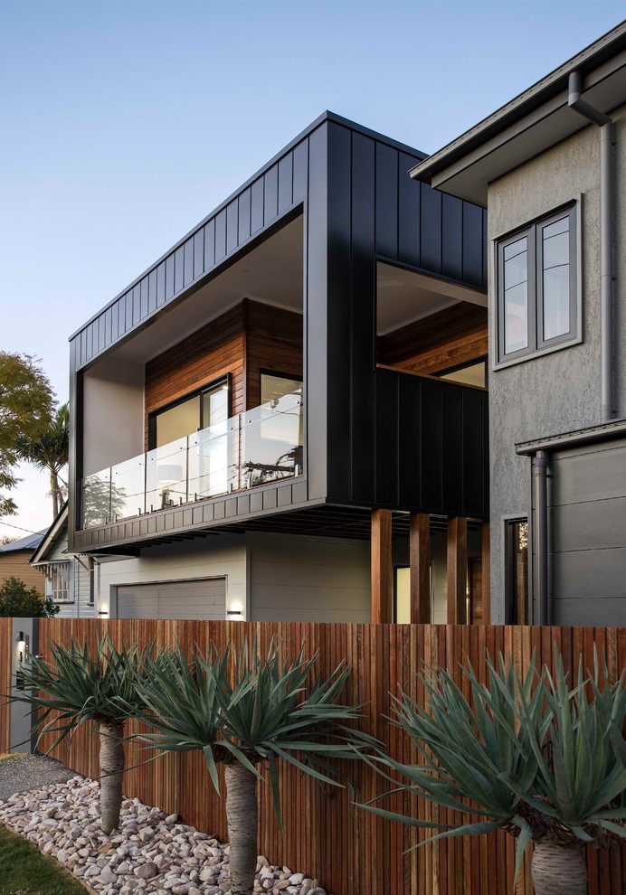 This is an example of a contemporary two-storey black exterior in Brisbane with mixed siding.