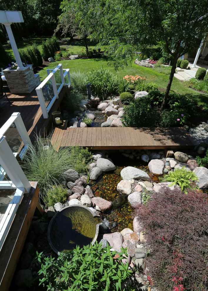 This is an example of an expansive transitional backyard garden in Chicago with a water feature.