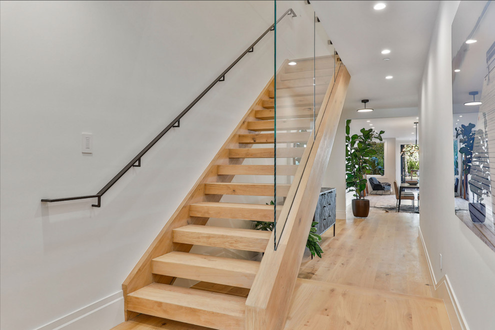Inspiration for a mid-sized contemporary wood straight staircase in San Francisco with open risers and glass railing.