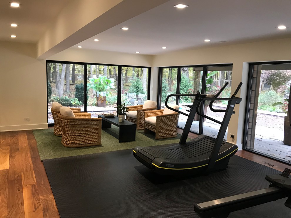 This is an example of a modern multipurpose gym in Chicago with white walls, dark hardwood floors and brown floor.