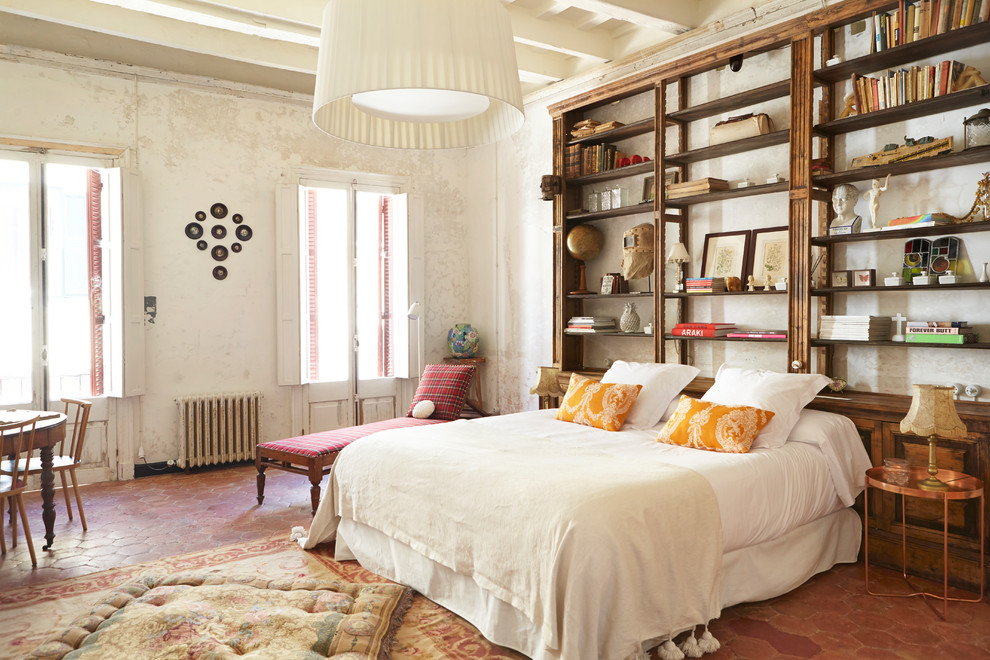 Design ideas for a large mediterranean master bedroom in Other with white walls, terra-cotta floors and red floor.