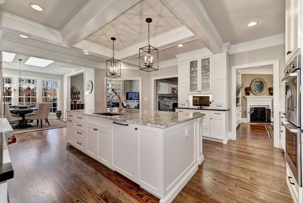 Eat-in kitchen - large transitional medium tone wood floor and brown floor eat-in kitchen idea in DC Metro with a single-bowl sink, recessed-panel cabinets, white cabinets, gray backsplash, ceramic backsplash, stainless steel appliances and an island