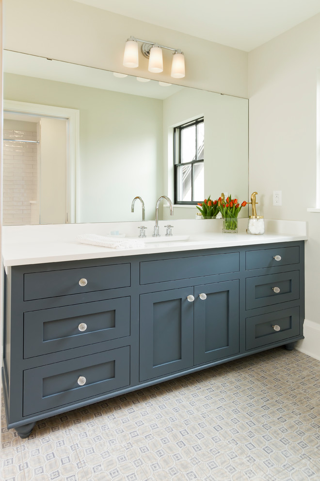 Design ideas for a mid-sized transitional bathroom in Minneapolis with shaker cabinets, blue cabinets, an alcove tub, a shower/bathtub combo, white tile, ceramic tile, green walls, porcelain floors, an undermount sink, engineered quartz benchtops, blue floor and a shower curtain.
