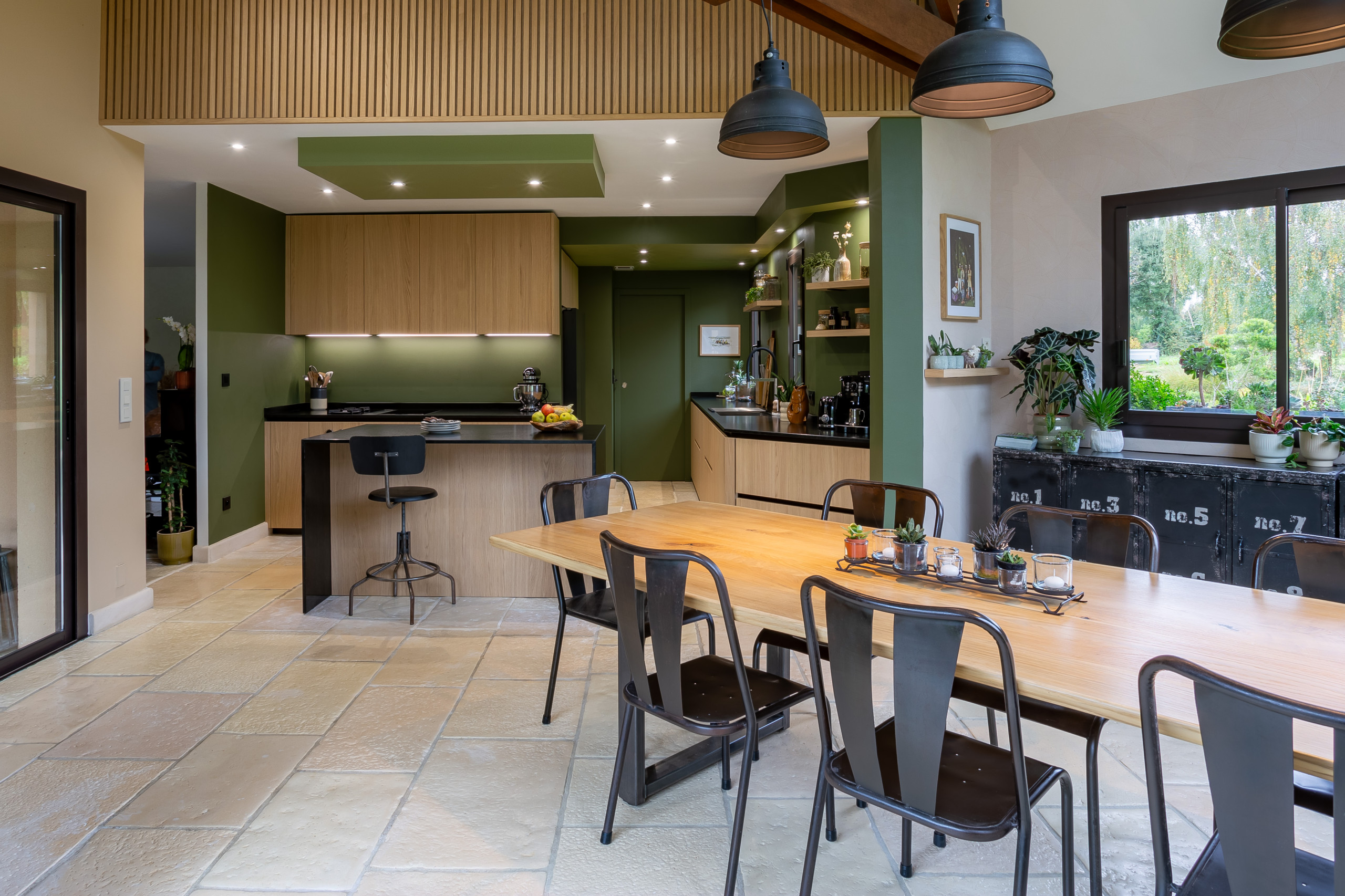 Réalisation d'une cuisine noire et bois dans un écrin végétal