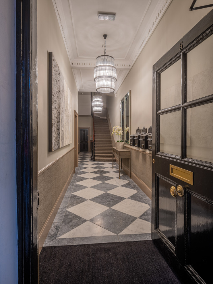 This is an example of a mid-sized traditional entry hall in London with beige walls, marble floors, a single front door, a black front door, multi-coloured floor and wallpaper.