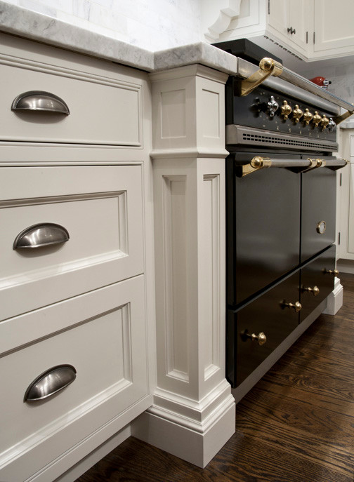Example of a large transitional medium tone wood floor eat-in kitchen design in Toronto with beaded inset cabinets, white cabinets, quartzite countertops, multicolored backsplash, stone tile backsplash, black appliances and an island