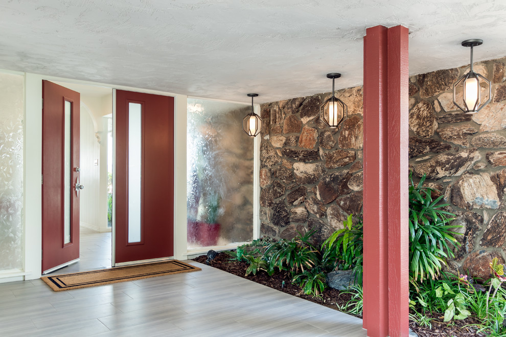 Inspiration for a large transitional front door in San Diego with red walls, porcelain floors, a double front door, a red front door and grey floor.