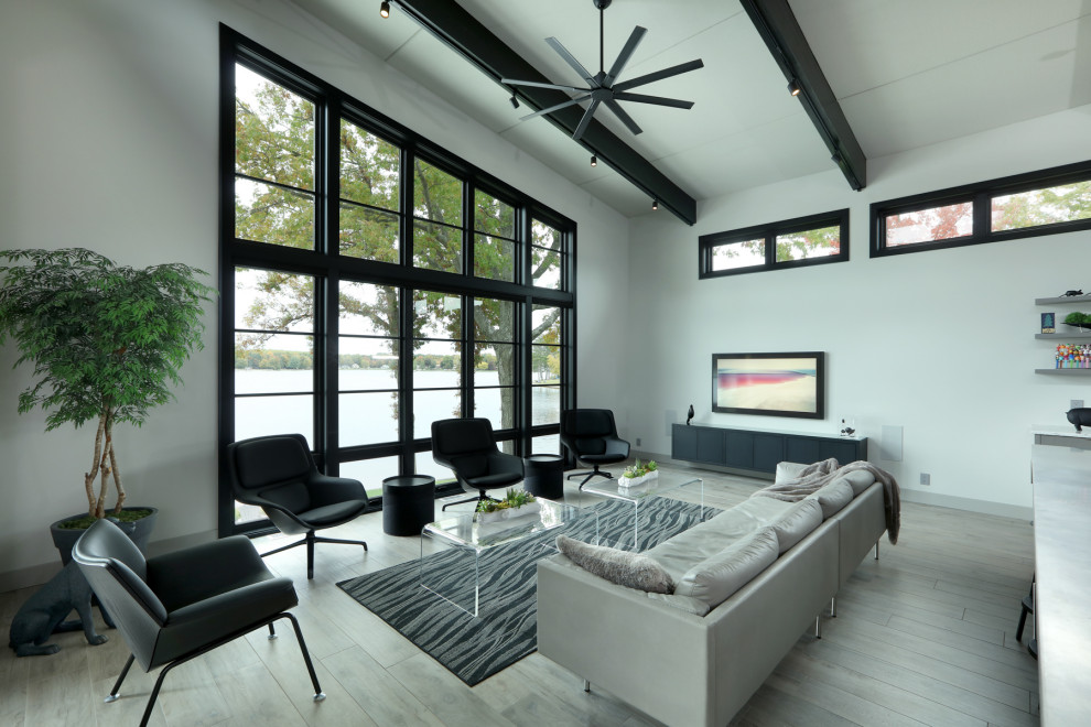 Esempio di un grande soggiorno moderno aperto con pareti bianche, parquet chiaro, pavimento beige e travi a vista