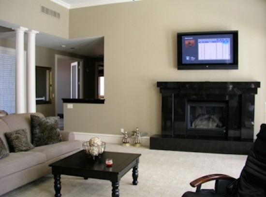 Family room - mid-sized enclosed carpeted family room idea in Detroit with white walls, a standard fireplace and a wall-mounted tv