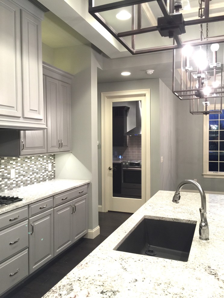 Example of a large transitional l-shaped vinyl floor and brown floor eat-in kitchen design in Cincinnati with an undermount sink, gray cabinets, granite countertops, multicolored backsplash, mosaic tile backsplash, stainless steel appliances, an island and raised-panel cabinets