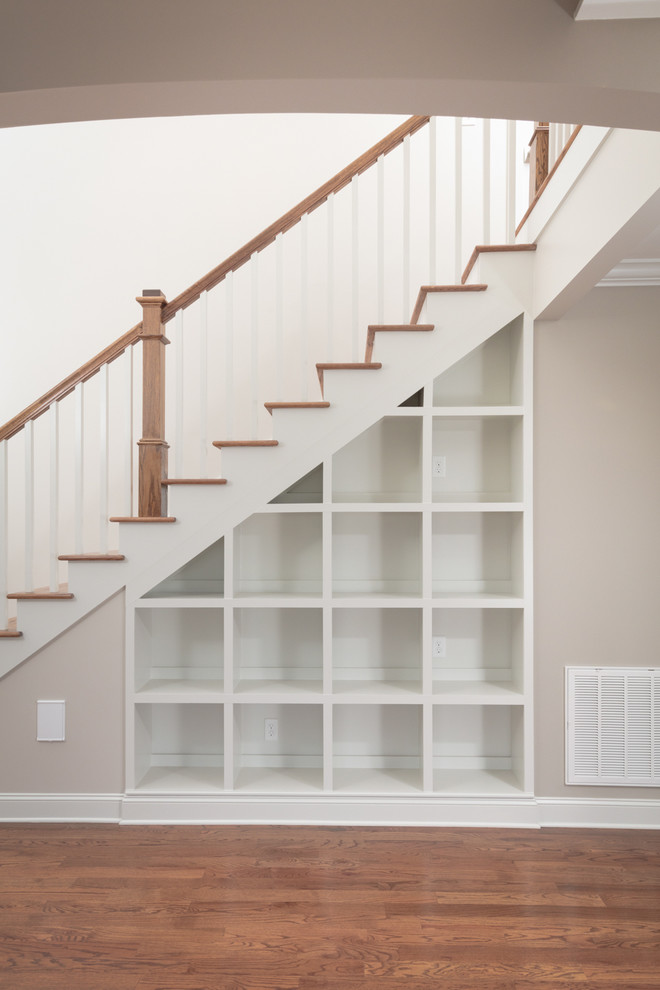 Example of a large transitional dark wood floor staircase design with gray walls