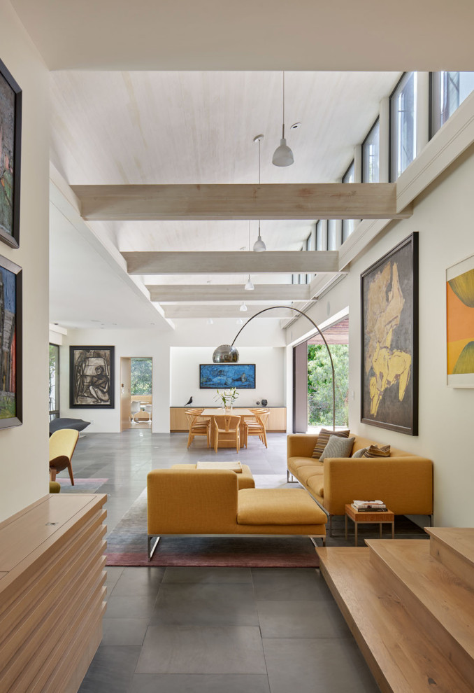 Diseño de salón abierto minimalista grande con paredes blancas, suelo de pizarra, suelo gris y vigas vistas