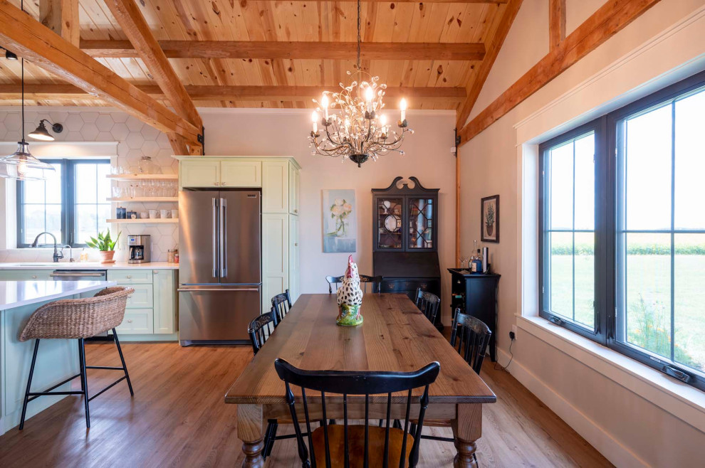 Mid-sized mountain style light wood floor, brown floor, vaulted ceiling and wood wall great room photo with beige walls and a hanging fireplace