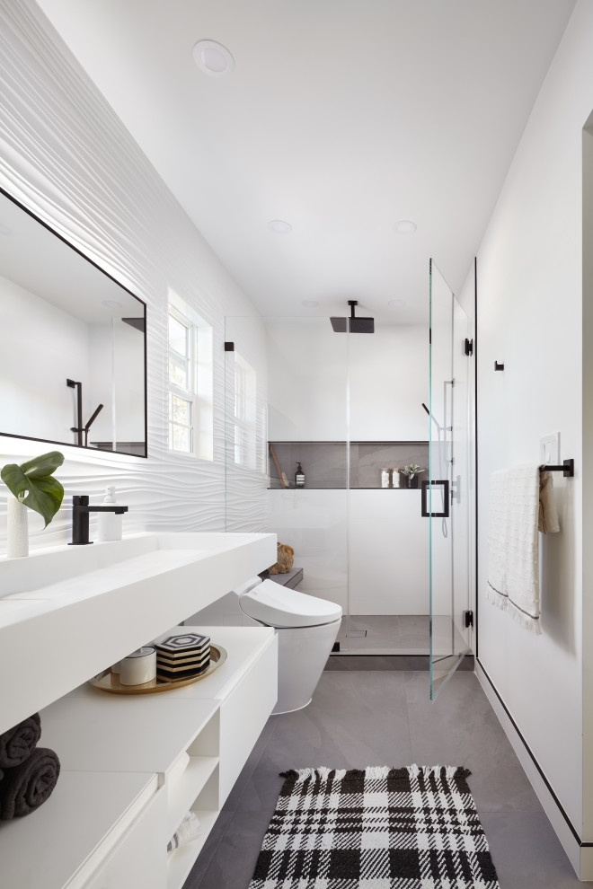 Cette image montre une grande douche en alcôve principale minimaliste avec un placard à porte plane, des portes de placard blanches, WC suspendus, un carrelage blanc, des carreaux de porcelaine, un mur gris, un sol en carrelage de porcelaine, un lavabo intégré, un plan de toilette en quartz modifié, un sol gris, une cabine de douche à porte battante, un plan de toilette blanc, un banc de douche, meuble double vasque et meuble-lavabo suspendu.