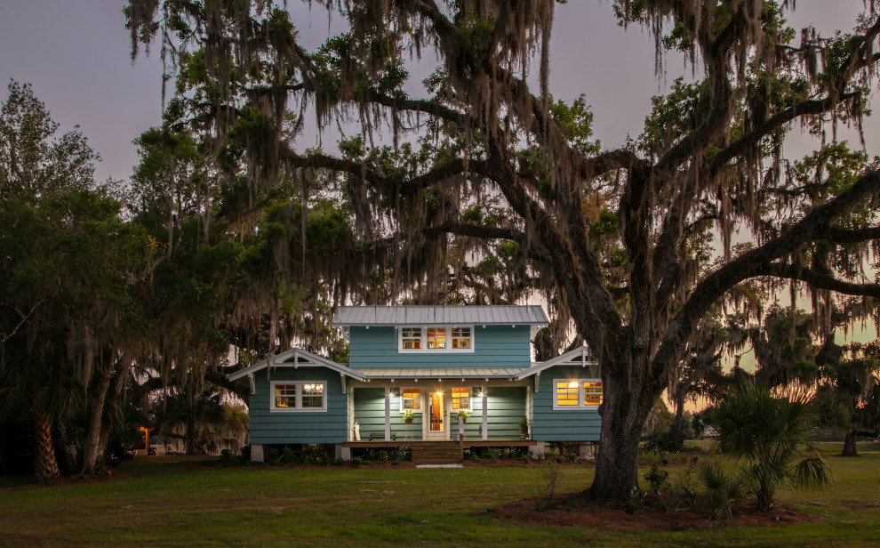Mittelgroßes, Zweistöckiges Landhausstil Haus mit blauer Fassadenfarbe, Satteldach, Blechdach, grauem Dach und Verschalung in Tampa