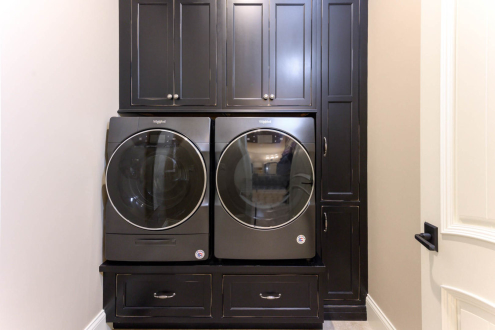 Inspiration for a mid-sized arts and crafts dedicated laundry room in Other with recessed-panel cabinets, black cabinets, white walls, a side-by-side washer and dryer and grey floor.