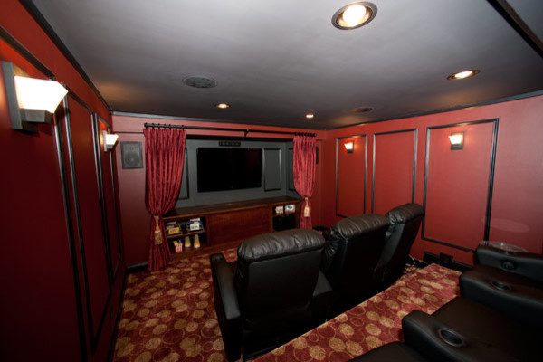 Design ideas for a mid-sized traditional enclosed home theatre in Chicago with red walls, carpet and a built-in media wall.