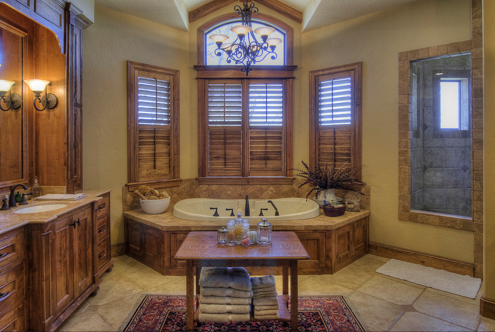 Design ideas for a traditional bathroom in Austin with an integrated sink, recessed-panel cabinets, medium wood cabinets, granite benchtops, a drop-in tub, an alcove shower, beige tile and ceramic tile.