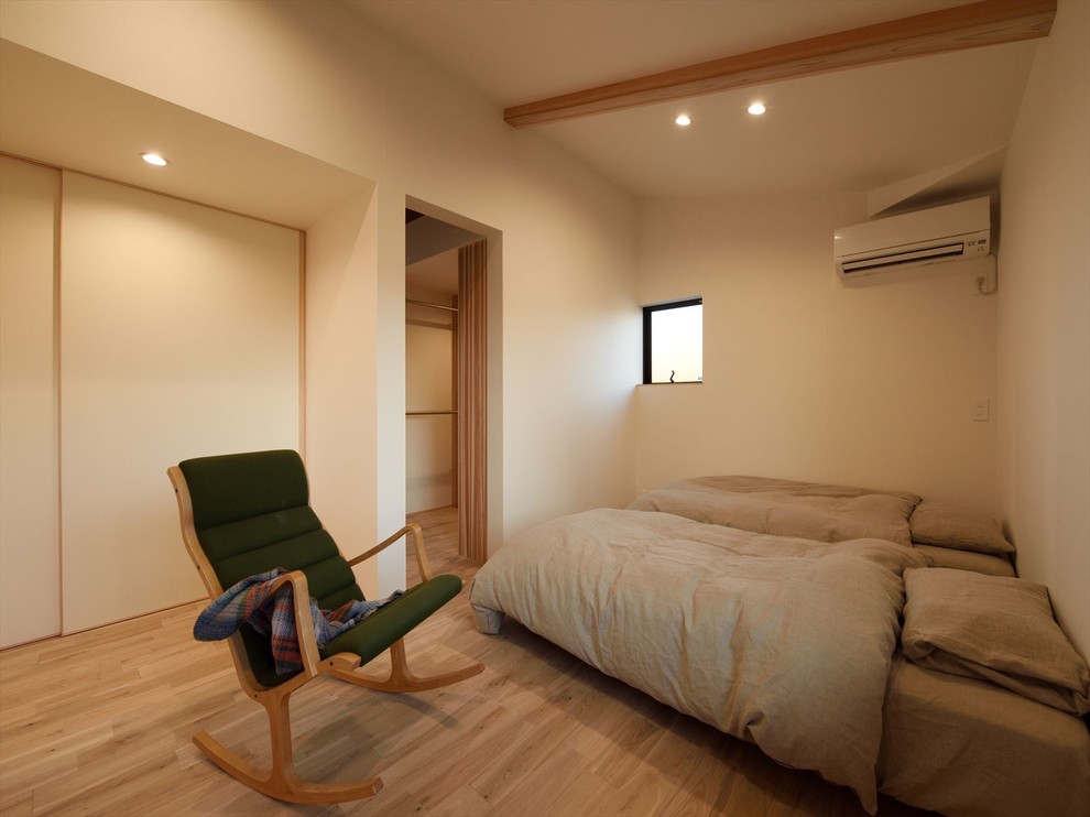 Esempio di una camera da letto etnica con pareti bianche, parquet chiaro e pavimento marrone