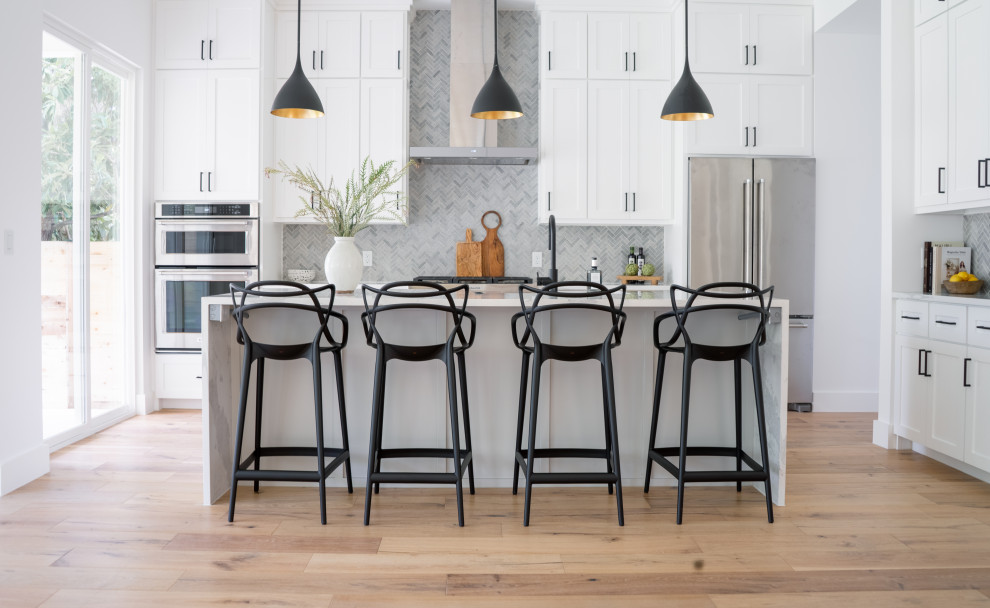 Transitional kitchen photo in Austin with a farmhouse sink, shaker cabinets, white cabinets, quartz countertops, gray backsplash and stone tile backsplash