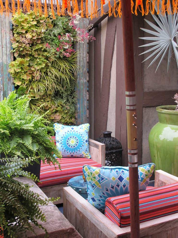 This is an example of a small eclectic patio in New York with a vertical garden, decking and no cover.