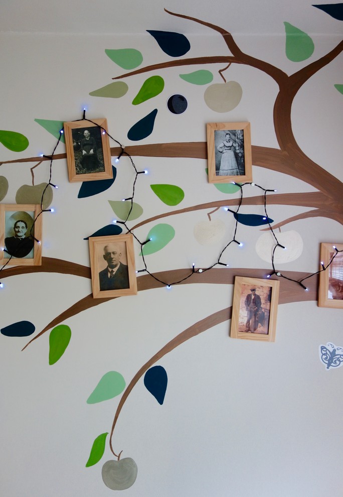 Photo of a small eclectic gender-neutral kids' playroom in Other with multi-coloured walls and medium hardwood floors.