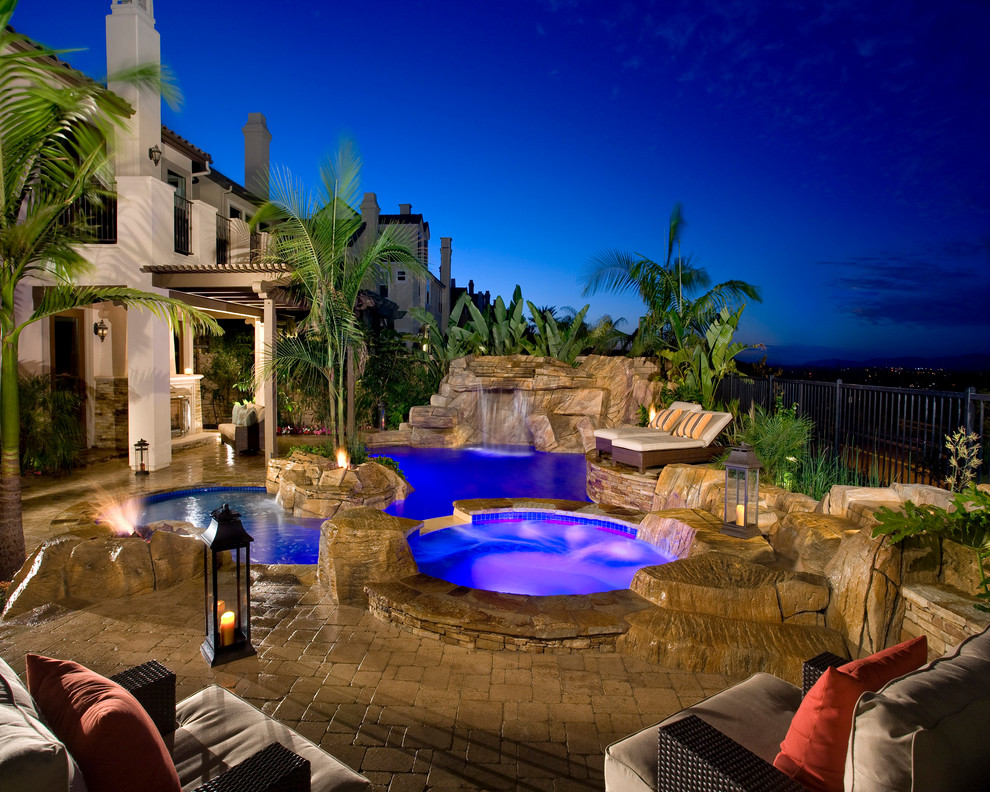 Design ideas for a mediterranean backyard custom-shaped natural pool in Orange County with a water feature.