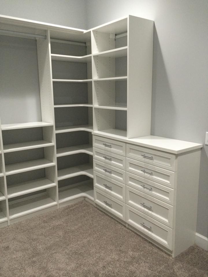 Design ideas for a transitional gender-neutral walk-in wardrobe in Jacksonville with raised-panel cabinets, white cabinets and carpet.