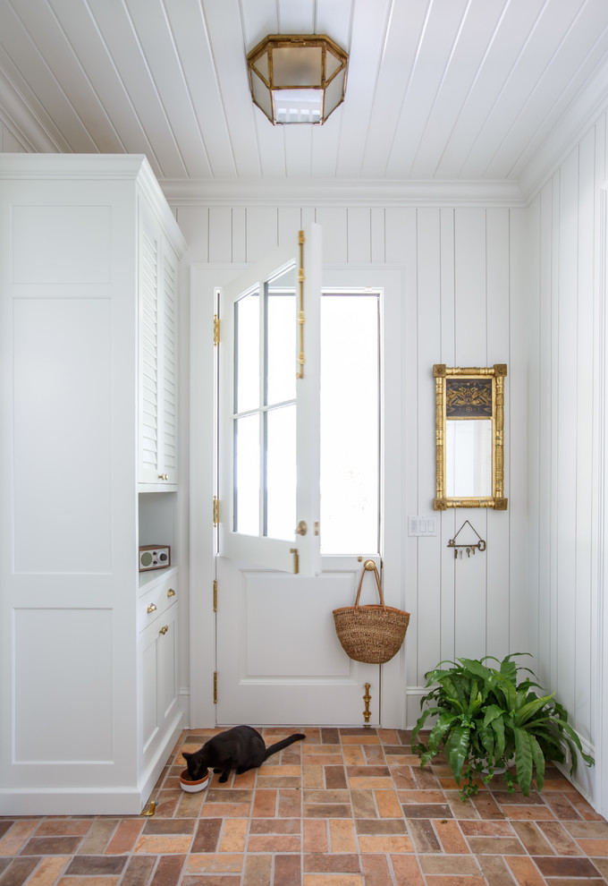 This is an example of a traditional mudroom in Jacksonville with white walls, a dutch front door, a white front door, multi-coloured floor and brick floors.