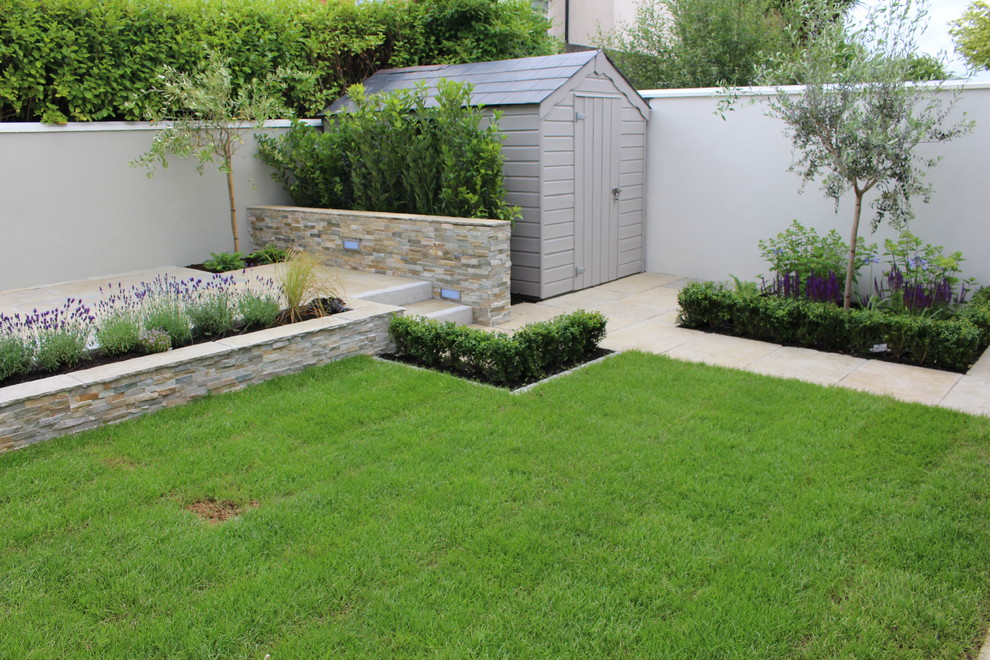 Design ideas for a traditional backyard partial sun garden in Dublin with natural stone pavers.