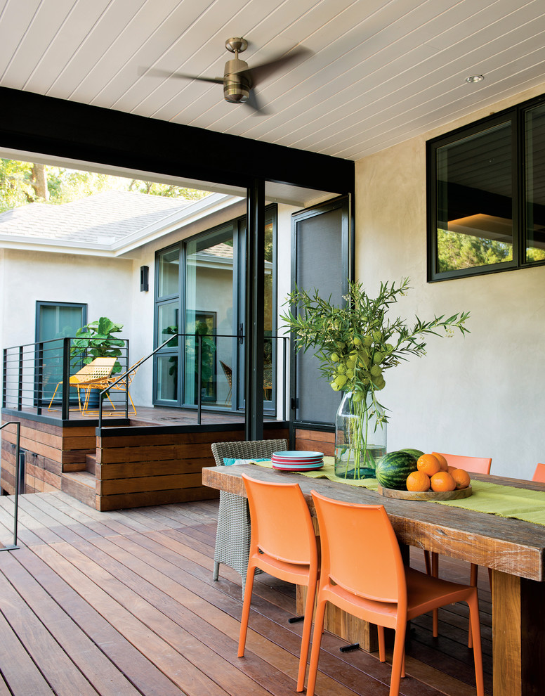 Inspiration for a contemporary backyard deck in Charlotte with a roof extension.
