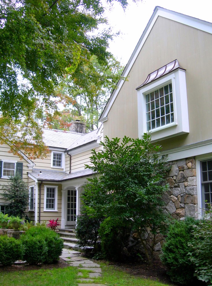 Mid-sized traditional exterior in New York with a gable roof and a tile roof.