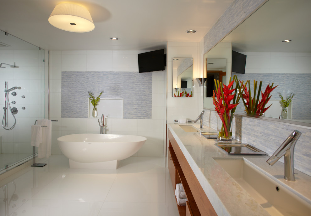 Inspiration for an expansive contemporary bathroom in Miami with an undermount sink, light wood cabinets, marble benchtops, a two-piece toilet, white tile, glass tile, white walls, marble floors, flat-panel cabinets, a freestanding tub, a double shower, white floor and a hinged shower door.
