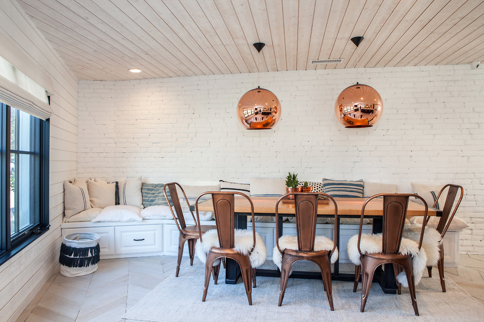 Country dining room in Los Angeles with white walls and light hardwood floors.