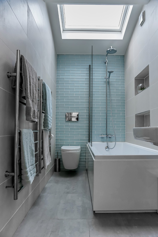 Photo of a mid-sized contemporary 3/4 bathroom in London with a shower/bathtub combo, a wall-mount toilet, grey walls, grey floor, an open shower, a corner tub and gray tile.