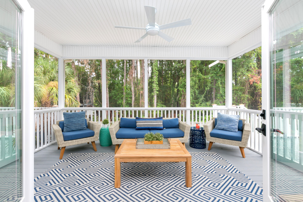Design ideas for a mid-sized beach style backyard screened-in verandah in Charleston with a roof extension.