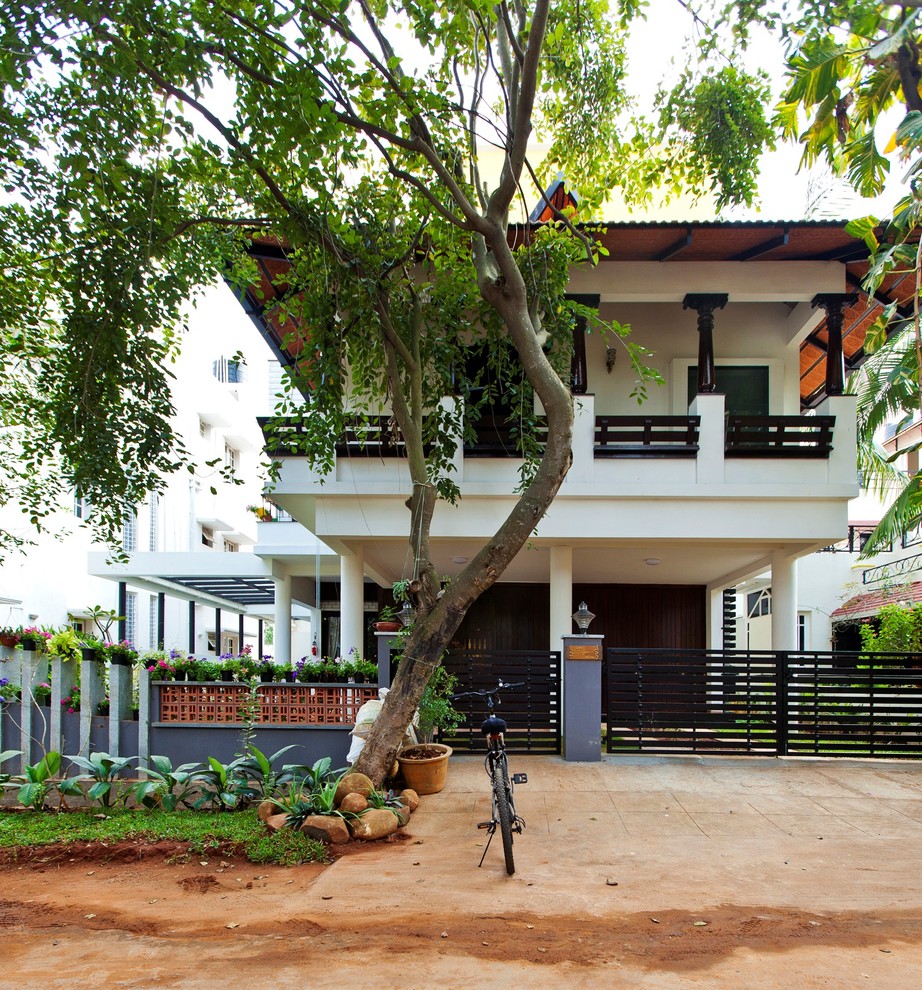 Asian two-storey white house exterior in Bengaluru with a hip roof and a tile roof.