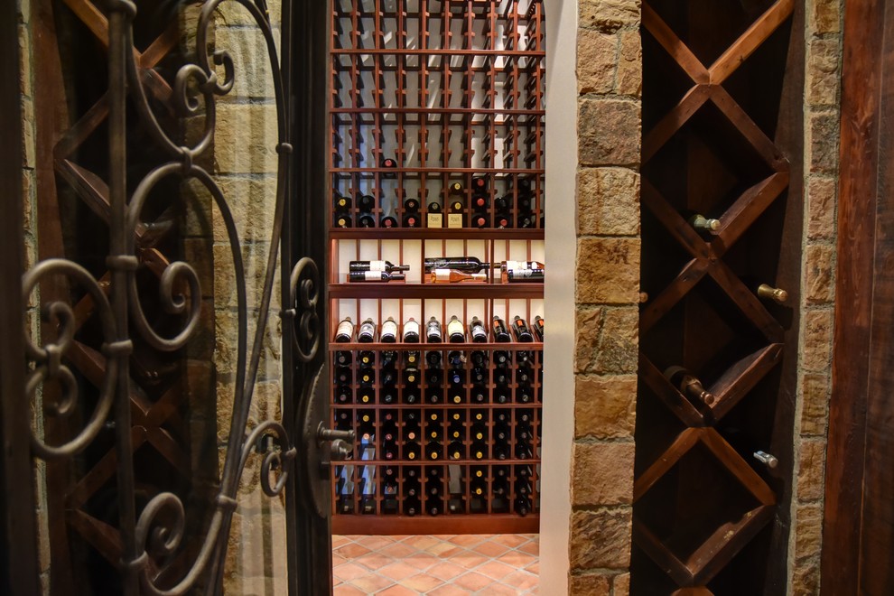 Aménagement d'une cave à vin contemporaine de taille moyenne avec tomettes au sol, un présentoir et un sol orange.