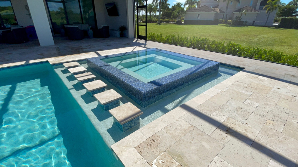 Imagen de piscina alargada costera grande rectangular en patio trasero con adoquines de piedra natural