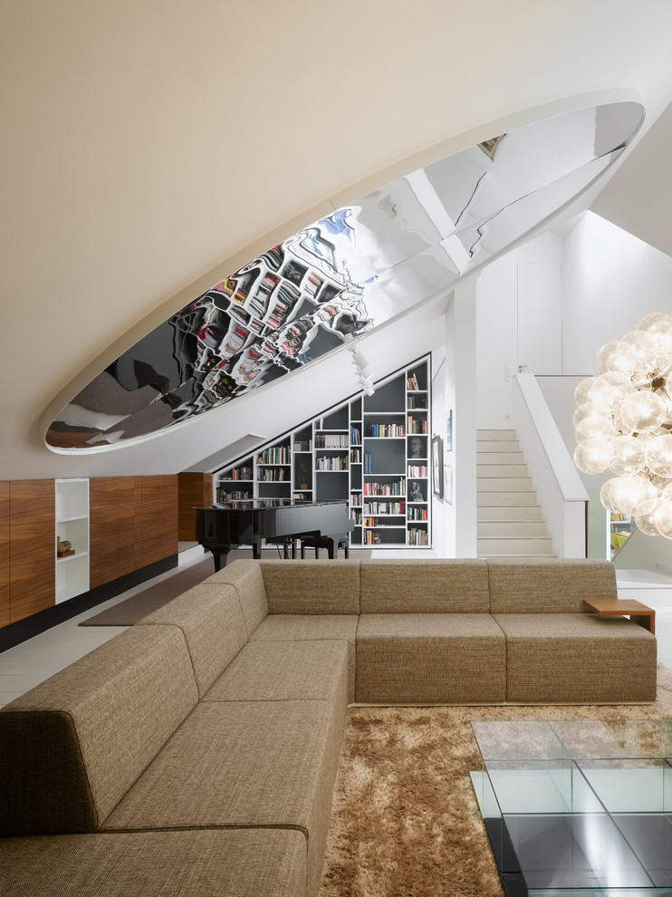 Expansive contemporary open concept living room in Stuttgart with a library and white walls.