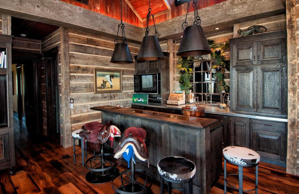 Inspiration for a mid-sized country galley seated home bar in Salt Lake City with dark hardwood floors, raised-panel cabinets, dark wood cabinets and mirror splashback.