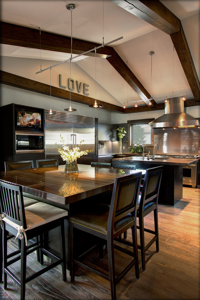Eat-in kitchen - huge transitional l-shaped medium tone wood floor and brown floor eat-in kitchen idea with quartzite countertops, an undermount sink, dark wood cabinets, stainless steel appliances and two islands