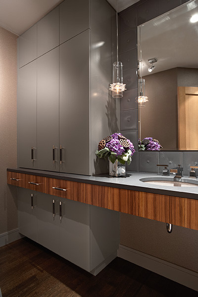 Inspiration for a mid-sized contemporary powder room in Minneapolis with an undermount sink, flat-panel cabinets, grey cabinets, engineered quartz benchtops, gray tile, beige walls and dark hardwood floors.