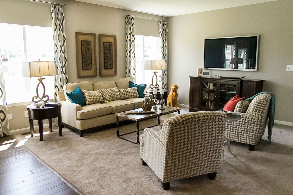 This is an example of a mid-sized transitional open concept living room in Baltimore with beige walls, carpet and a wall-mounted tv.