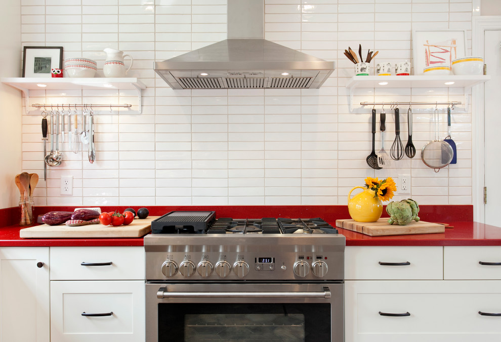 Inspiration for a scandinavian eat-in kitchen in Bridgeport with an undermount sink, shaker cabinets, white cabinets, quartz benchtops, white splashback, ceramic splashback, stainless steel appliances, porcelain floors, a peninsula and red benchtop.