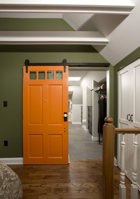 This is an example of a large industrial hallway in DC Metro with green walls, medium hardwood floors and brown floor.