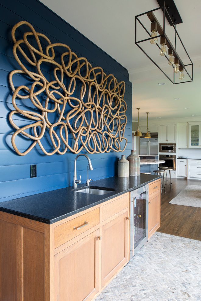 Small transitional single-wall wet bar in Minneapolis with an undermount sink, recessed-panel cabinets, light wood cabinets, quartz benchtops, blue splashback, shiplap splashback, ceramic floors, grey floor and black benchtop.