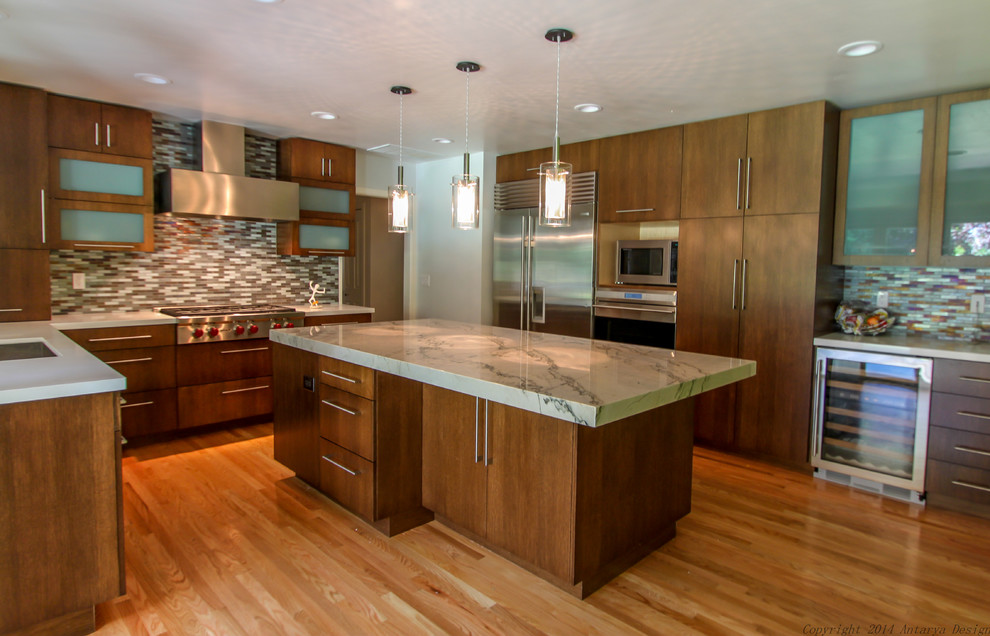 This is an example of a large contemporary l-shaped separate kitchen in San Francisco with an undermount sink, flat-panel cabinets, dark wood cabinets, marble benchtops, multi-coloured splashback, mosaic tile splashback, stainless steel appliances, medium hardwood floors, with island, brown floor and white benchtop.